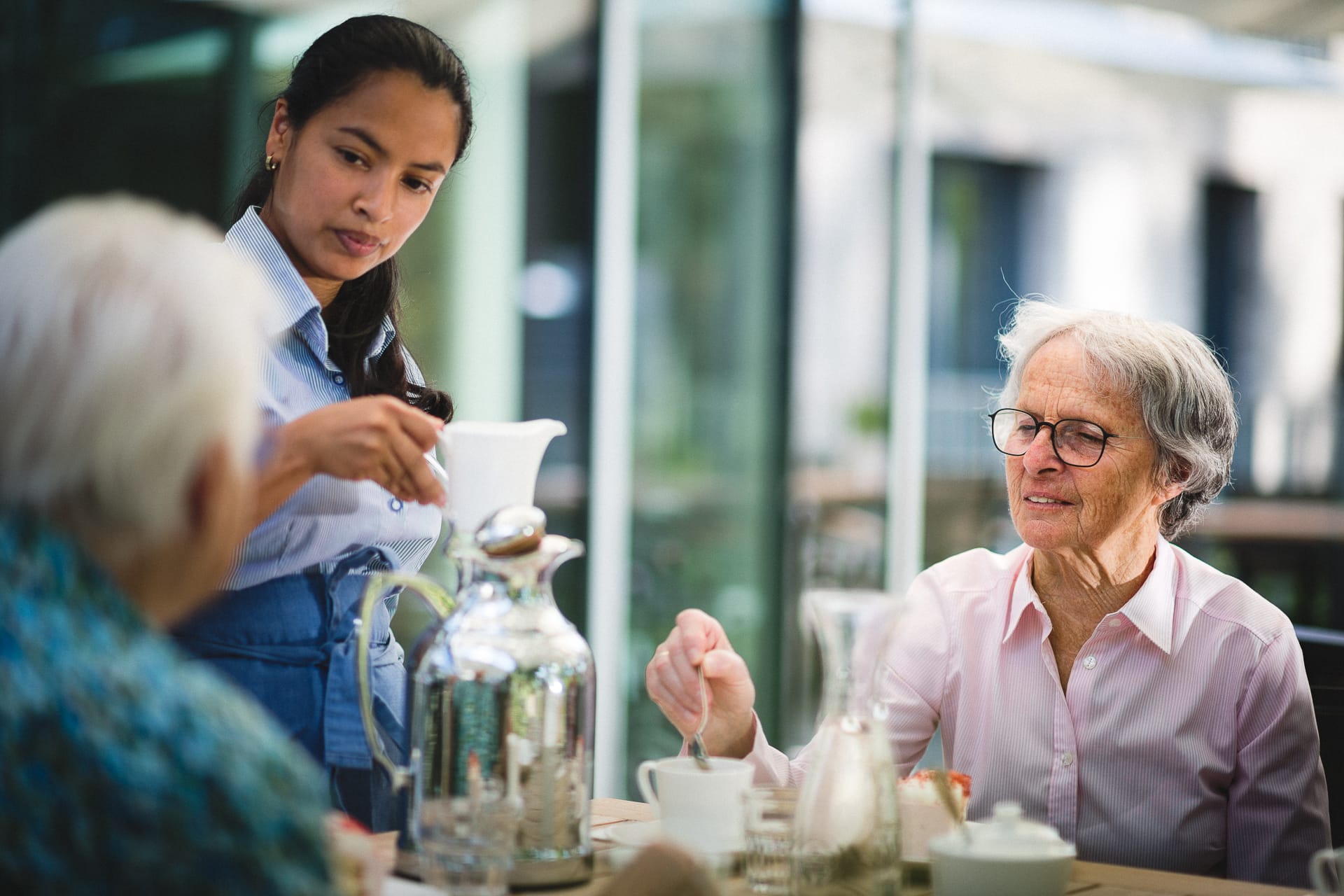 Zwei Frauen bekommen Kaffee und Kuchen auf Terrasse im Pflegeheim in Hannover Landhaus Pflege und Wohnen