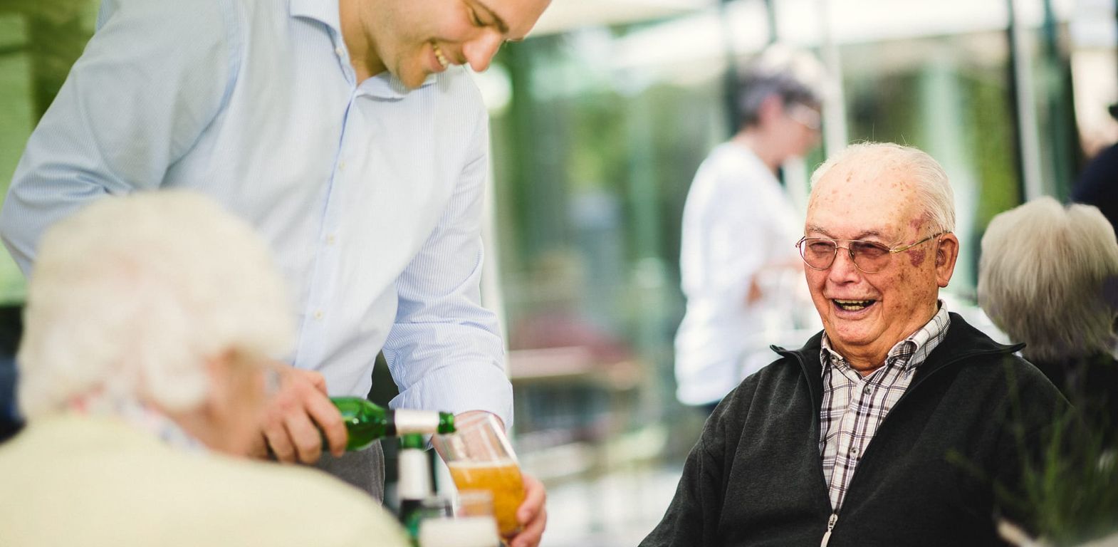 Terrasse Restaurant Mann bekommt Bier eingeschenkt Pflegeheim in Hannover Landhaus Pflege und Wohnen