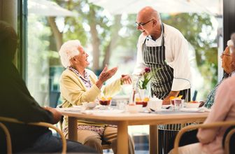 Koch und ältere Frau unterhalten sich im Restaurant im Pflegeheim in Hannover Landhaus Pflege und Wohnen