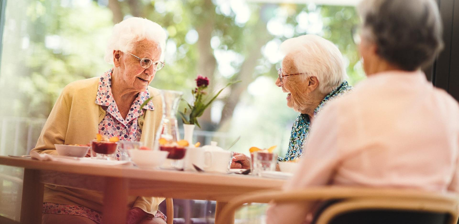 Terrasse drei Frauen beim Nachtisch Mittagessen im Pflegeheim in Hannover Landhaus Pflege und Wohnen